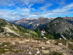 Woman photographing mountain peaks