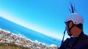 A paragliding man looking over the Cape Town shore