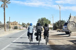 Three hijabi bicyclists in Merzouga