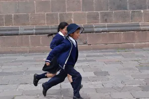 Running children in blue school uniforms