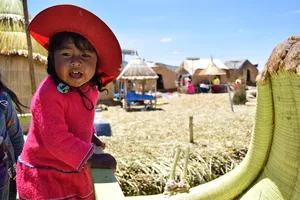 Girl in pink on floating island, Lake Titicaca