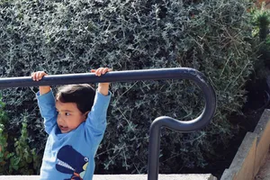 Kid hanging from a rail