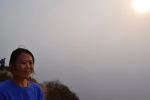 Woman on a cliff above fog