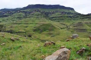 Green hills beneath a rocky plateau