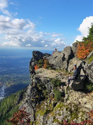 Person on a mountain promontory overlooking a valley