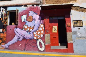 Street art of a large purple woman in daisy swimwear