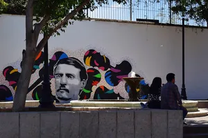 Shady park with mural of mustached man